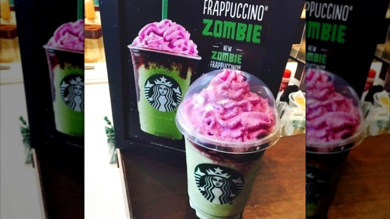 Zombie Frappuccino being gripped by green hand with smoky purple background