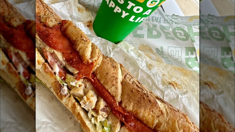 Close up of Chicken Pizziola sandwich on wrapper with drink's cup, mirrored image