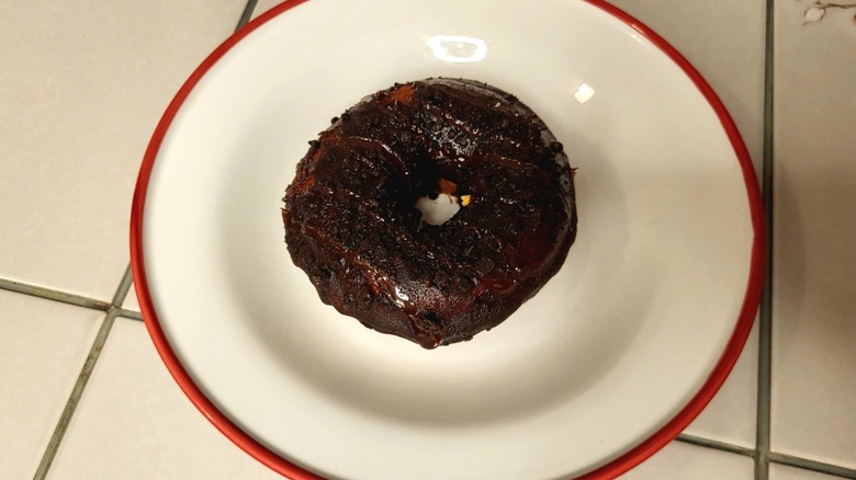 A donut topped with chocolate frosting and crushed Oreos.