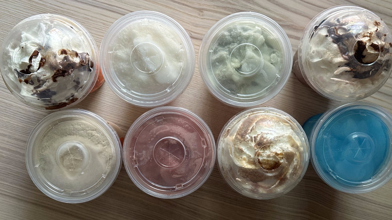 Eight frozen Dunkin' drinks on wooden table