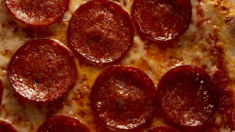Pile of pepperoni on white background