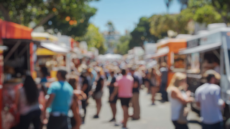 Blurry photo of customers at food trucks.
