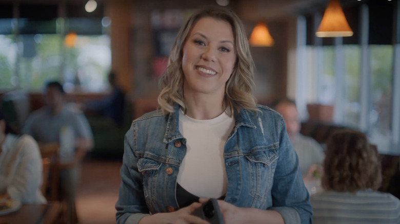 Jodie Sweetin smiling in a 2023 Sizzler commercial.