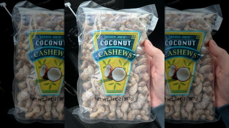A transparent bag full of cashews dusted with a white-colored seasoning. A logo displays the words "Trader Joe's Coconut Cashews" in white and yellow text on a blue backdrop, with an image of a coconut split in half.