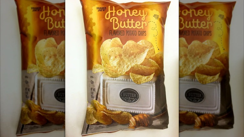 A golden bag labeled "Honey butter flavored potato chips" with an image of chips atop a case of butter with some honey on a dipping stick beneath it.