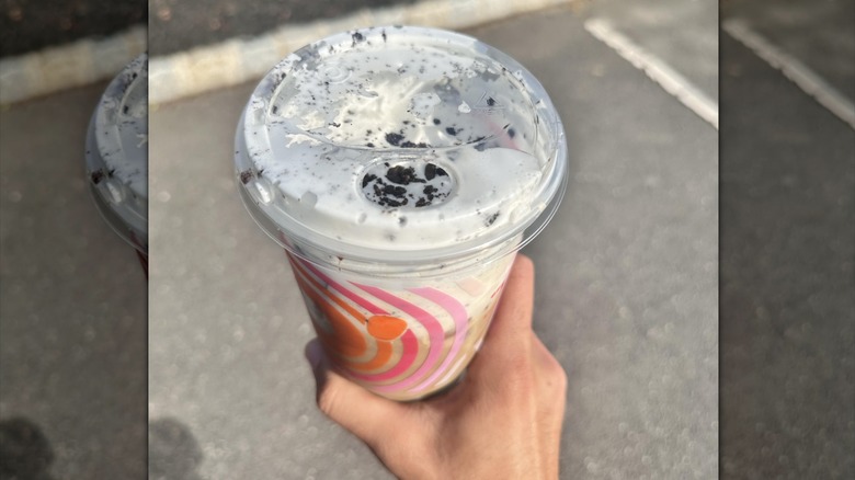 Hand holding Dunkin' Donuts OREO Cloud Latte.
