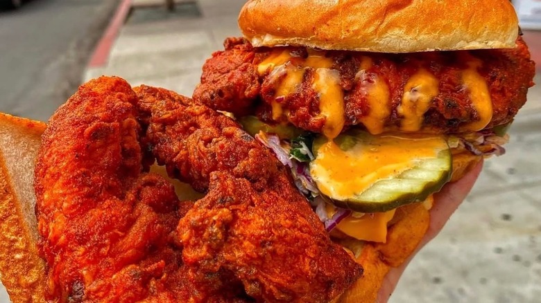 Someone holding two chicken menu items from Dave's Hot Chicken