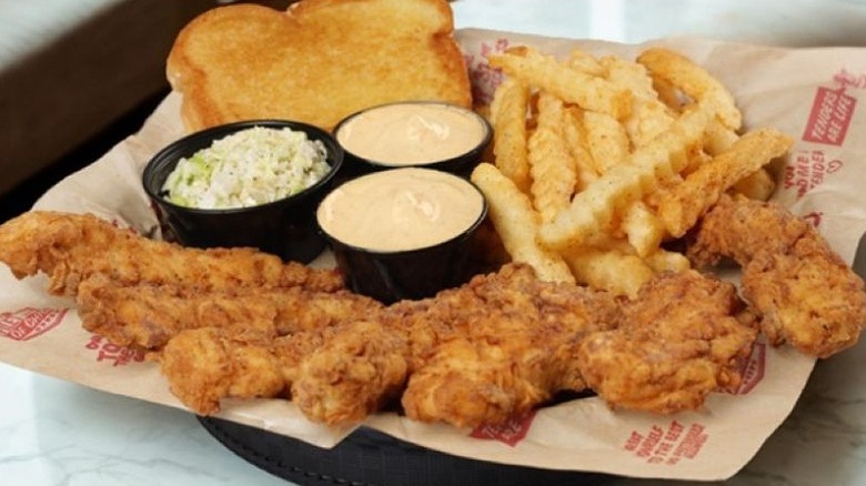 Huey Magoo's crispy chicken tenders with fries, Texas toast, coleslaw, and sauce.