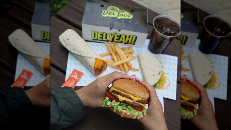 A person holding a Del Taco burger
