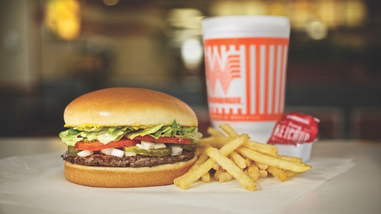 A Whataburger burger with fries and a drink