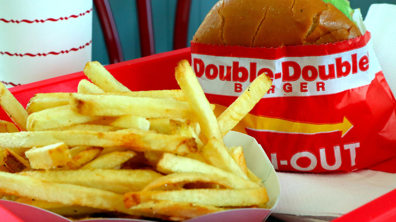 A hamburger and fries from In-N-Out on a red tray