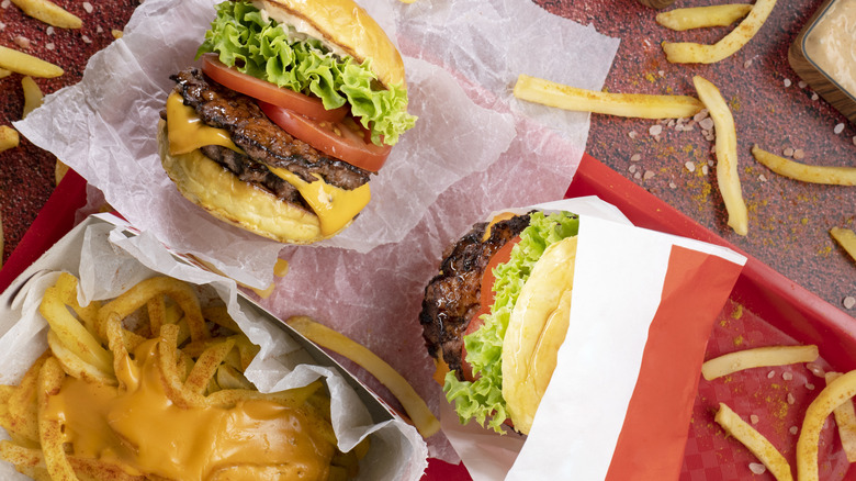 fast food cheese burger and fries top view on a table
