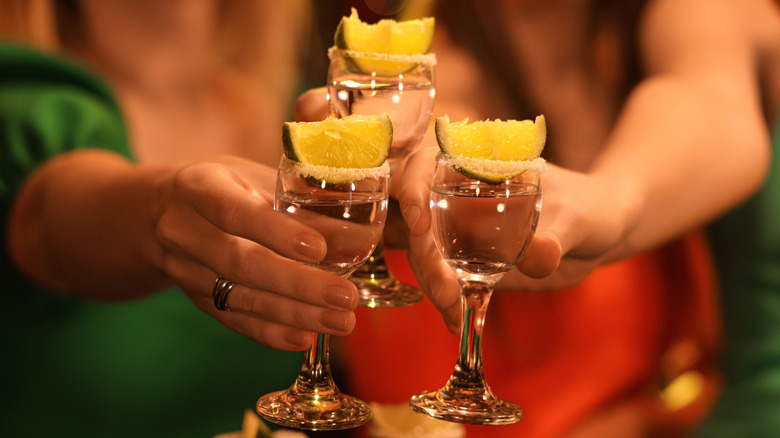 People toasting three shots of tequila