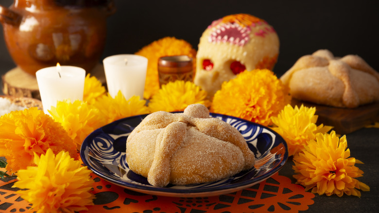Pan de muerto surrounded by marigolds
