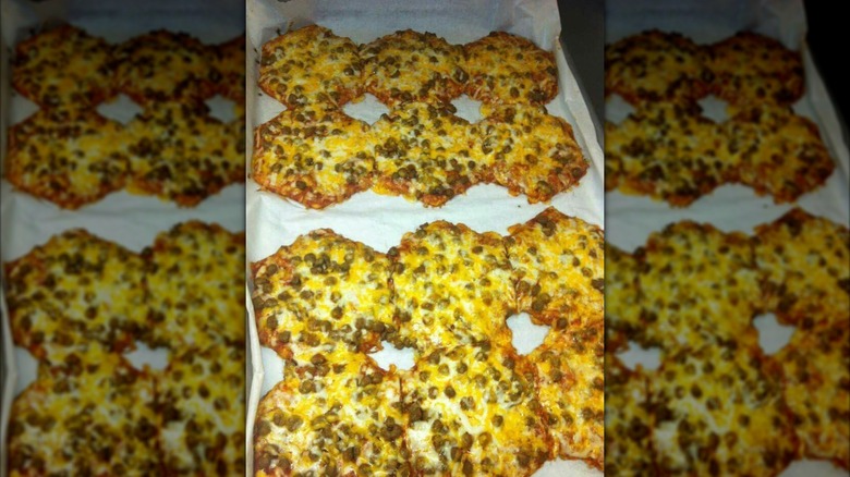Octagonal cheese and meat mini pizzas on tray