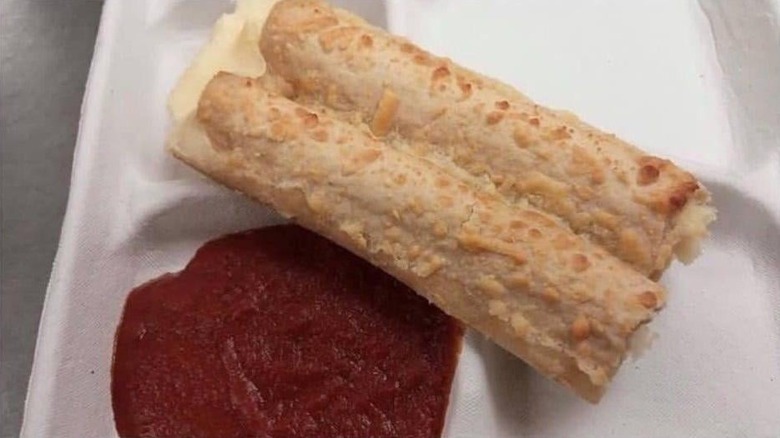 Cheese-filled breadsticks on lunch tray with marinara sauce