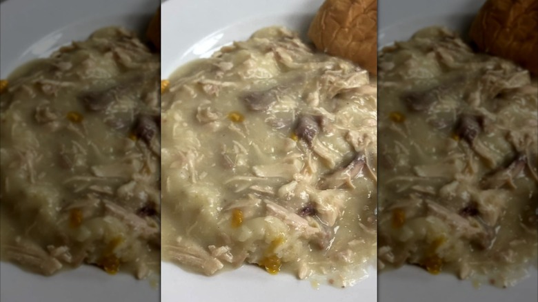 Plate of turkey and gravy with dinner roll