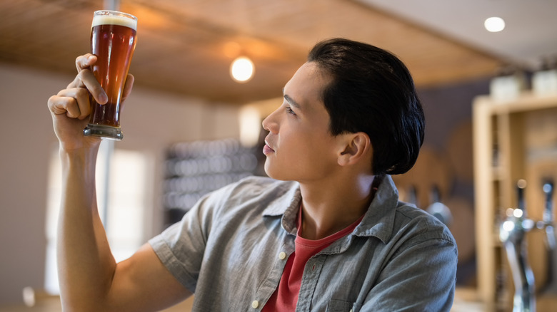 person looking at glass of beer