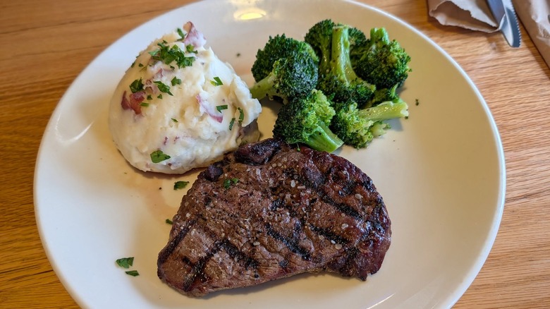 Top sirloin, mashed potatoes, and broccoli on white plate from Applebee's