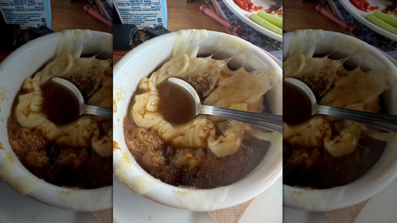 Applebee's French onion soup with spoon in white bowl