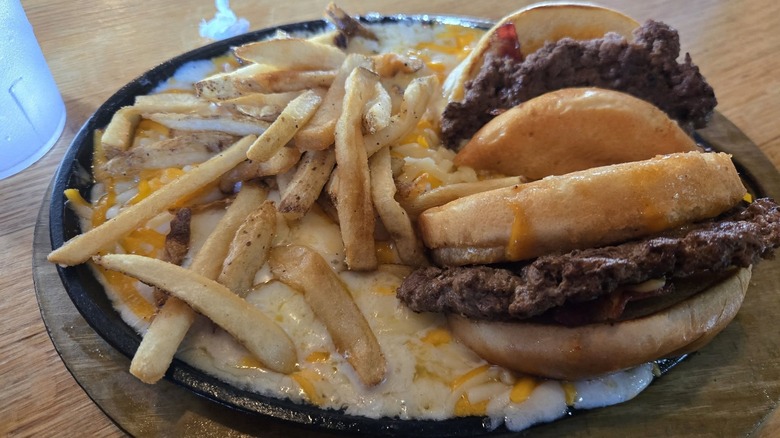 Applebee's hamburger and fries on a bed of cheese