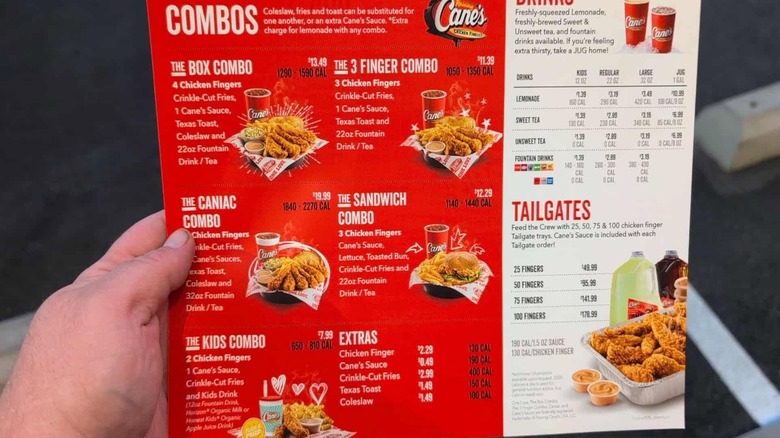 Person holding Raising Cane's menu