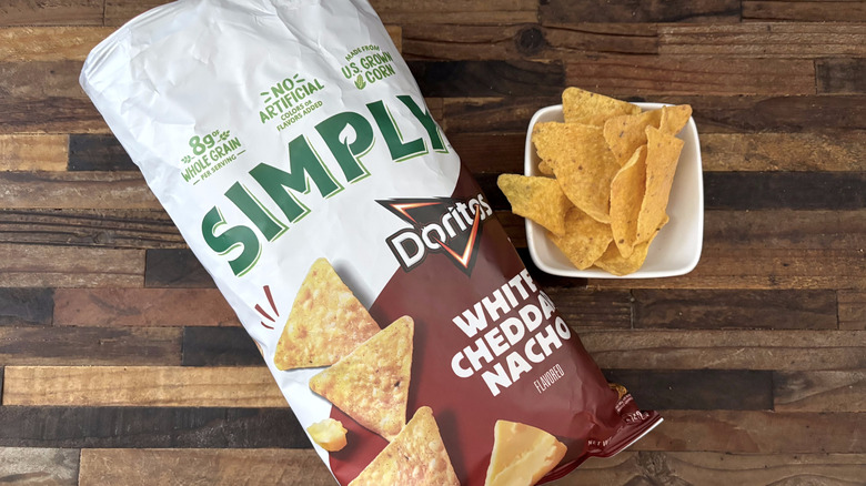 Simply Doritos White Cheddar Nacho in bag and white bowl on wooden table