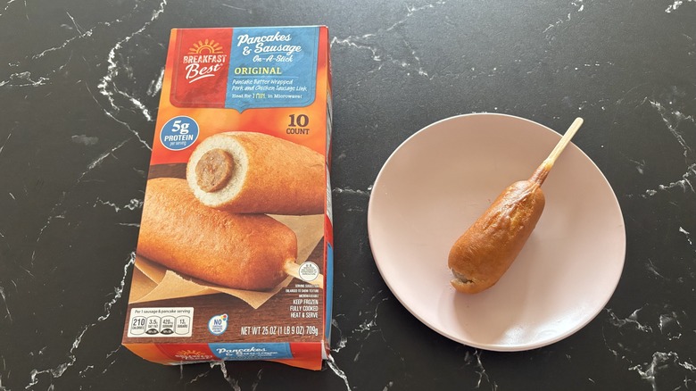 Aldi pancake sausage sticks box next to pancake sausage stick on plate