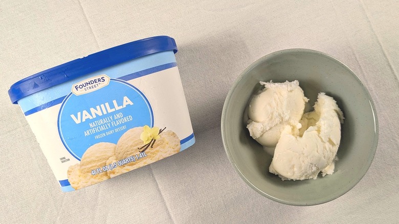A bowl of vanilla ice cream next to a container of Founders Street Vanilla Frozen Dessert