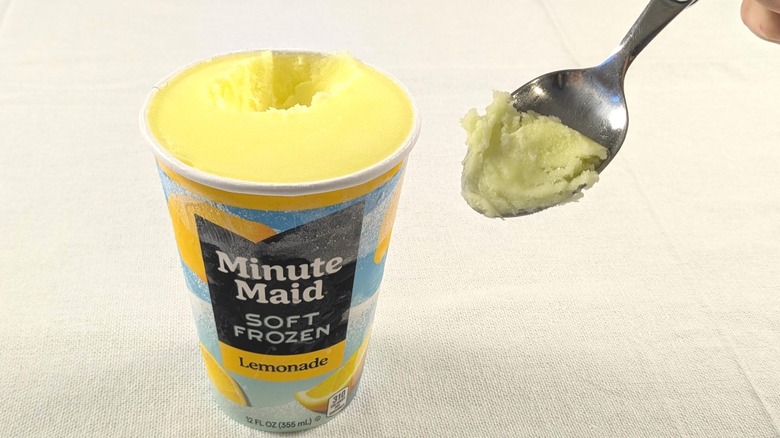 A spoon scooping out some frozen lemonade from a Minute Maid container