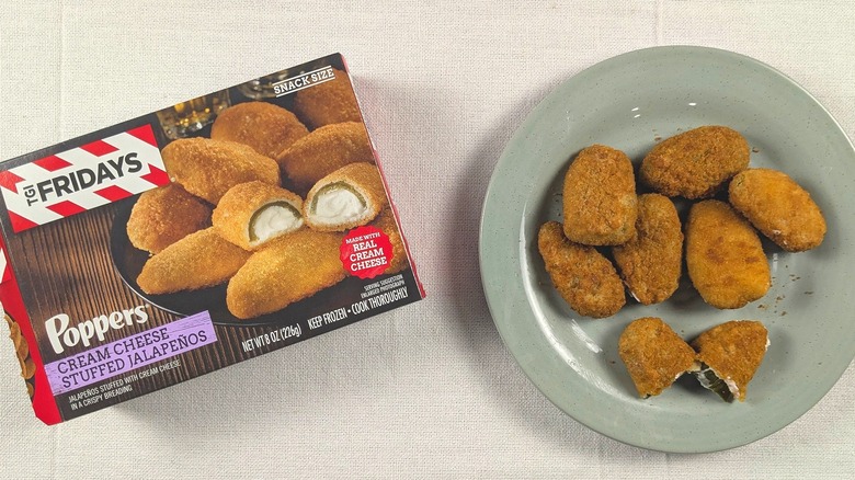 A plate of jalapeño poppers next to a box of TGI Fridays jalapeño poppers