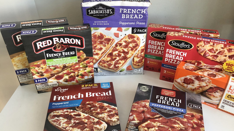 8 different frozen French bread pizzas in their boxes.