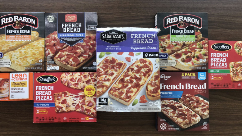 8 different frozen French bread pizzas laid out in their boxes.