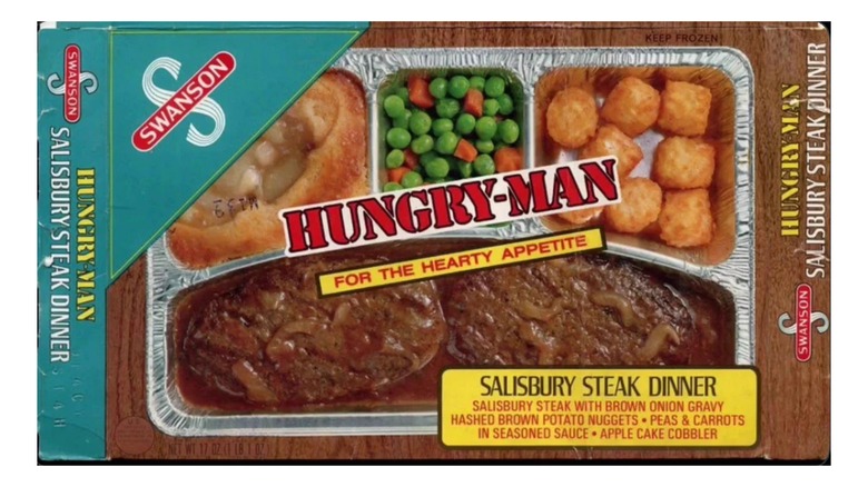 A plate of steak and vegetables on an aluminum tray