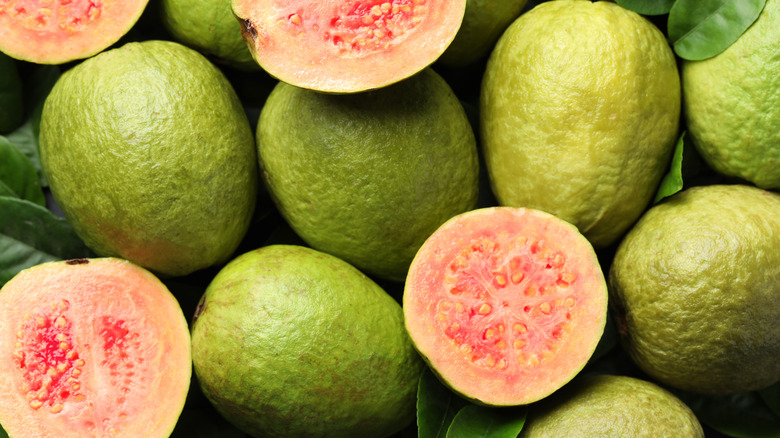 Pile of guava fruits with some cut in half