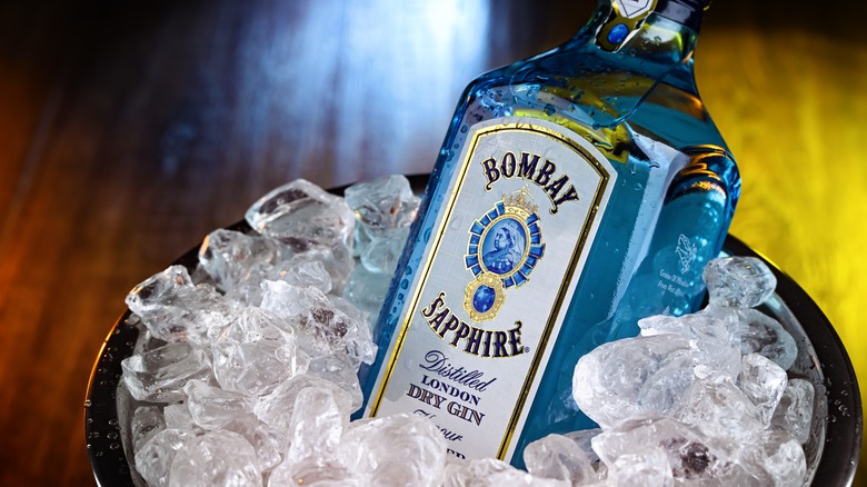 A full bottle of Bombay Sapphire London Dry Gin resting in a full ice bucket