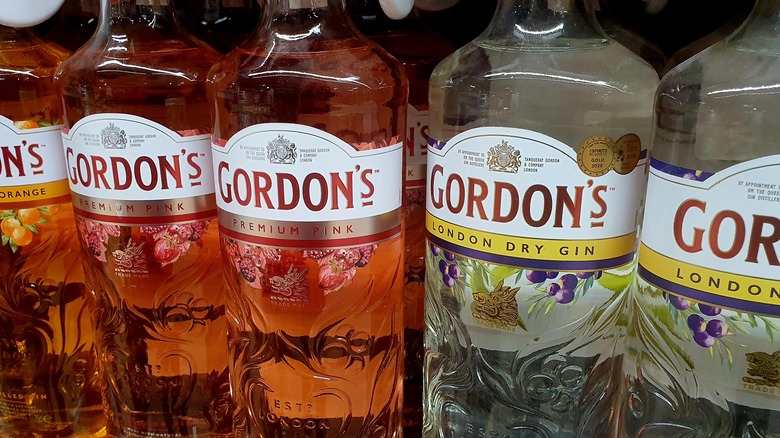 A line of Gordon's gin products on a shop shelf, including its orange, pink and London dry gin.