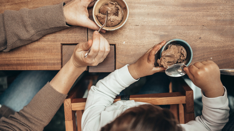 Overhead shot of parent and child eating ice cream from bowls