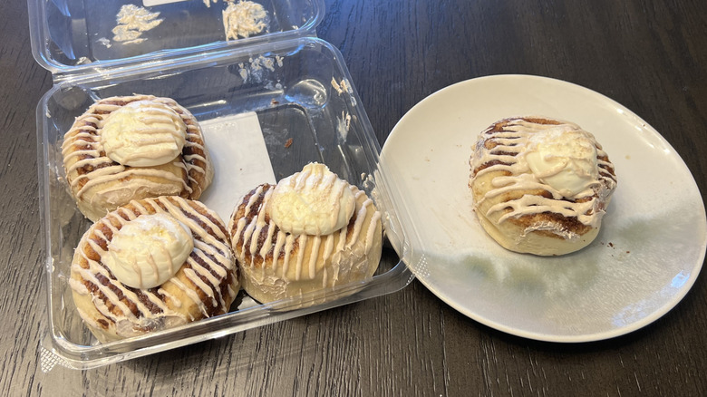 Walmart Marketside cinnamon rolls in a plastic container and on a white plate