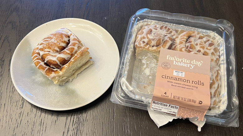 Target Favorite Day cinnamon rolls in a plastic-lid container and a whole roll on a white plate