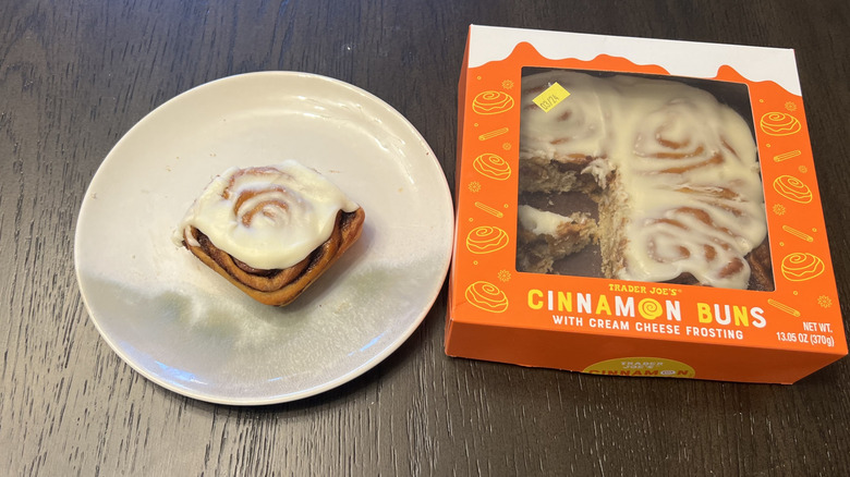 Box of Trader Joe's cinnamon buns and a whole bun on a white plate