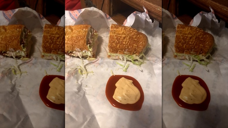 Chipotle mayo and ketchup next to a Jersey Mike's sub on paper