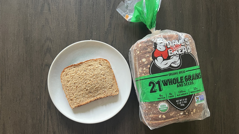 Slice of Dave's Killer Bread 21 Whole Grains and Seeds bread on a plate.