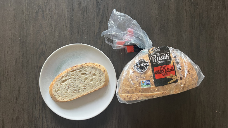 Slice of The Rustik Oven Hearty Grains & Seeds bread on a plate.