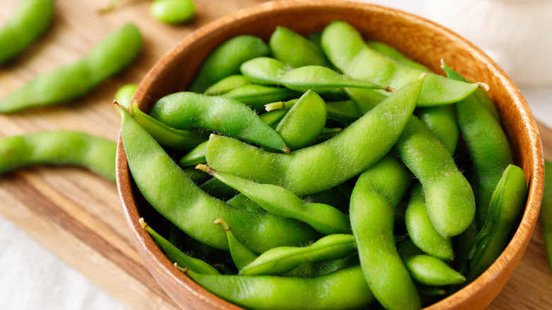 Edamame beans in their pods, in a wooden bowl