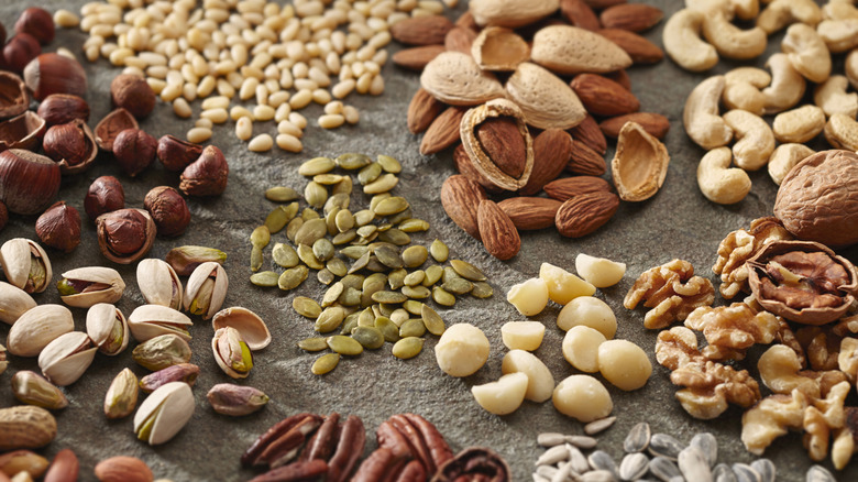 Various nuts and seeds on a slate background