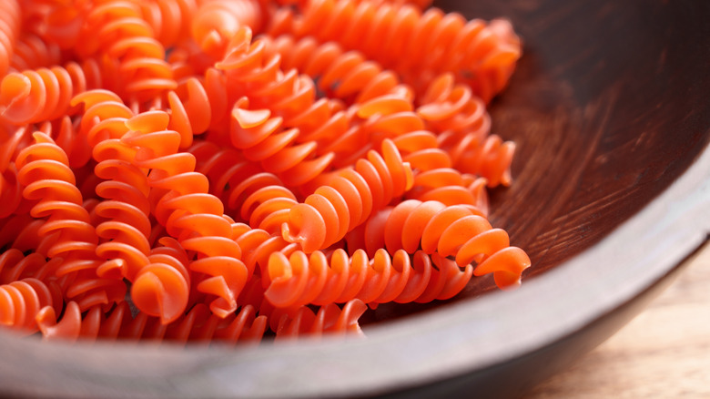 Close up of red lentil fusilli in a black bowl
