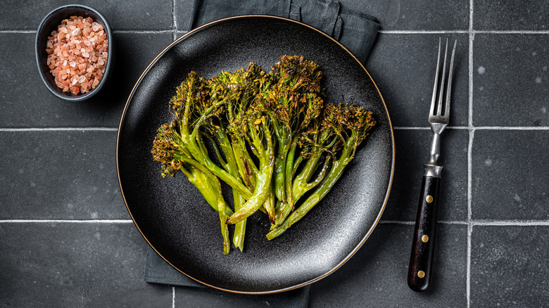 Roasted broccolini on black plate
