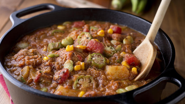 Close-up of Brunswick stew with wooden spoon in cast iron pot