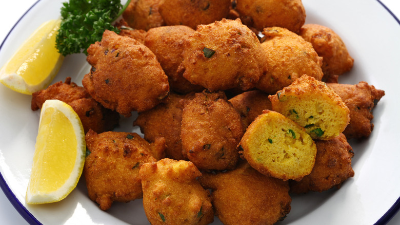 Hushpuppies in a white bowl with lemon